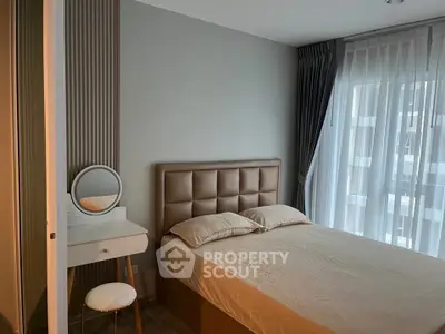 Modern bedroom with stylish decor and natural light from large windows.