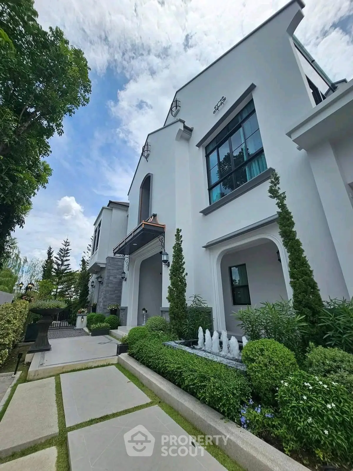 Elegant modern house exterior with lush landscaping and stylish architecture.