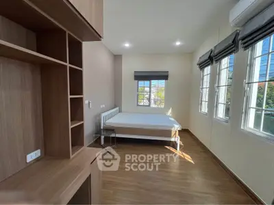 Spacious bedroom with large windows and wooden flooring, perfect for natural light lovers.