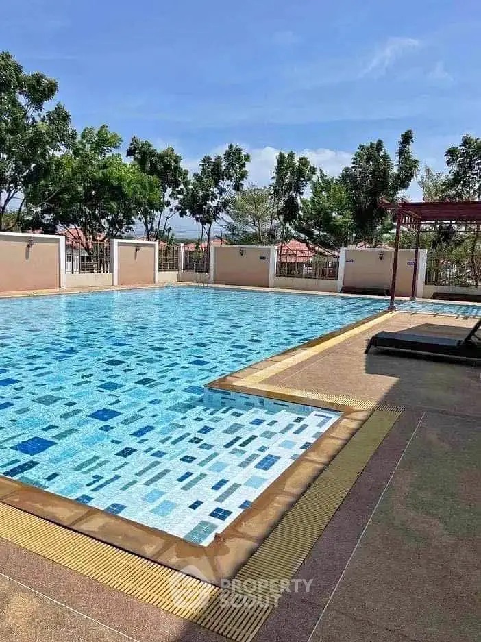 Luxurious outdoor swimming pool with clear blue water and surrounding greenery.