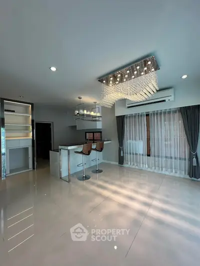 Elegant modern living room with chandelier and open kitchen layout