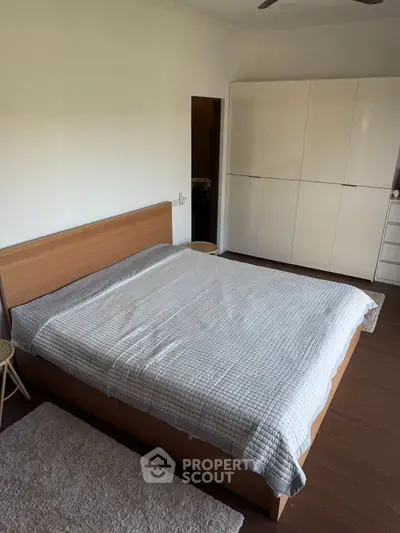 Spacious bedroom with modern furniture and ample natural light.