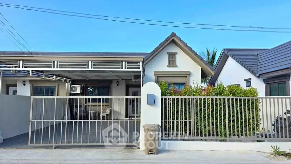 Charming single-story house with gated driveway and modern exterior design.