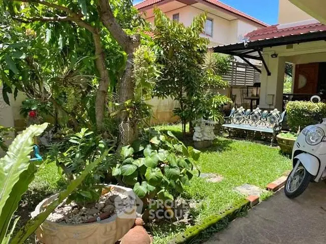 Charming garden with lush greenery and cozy seating area in a residential property.