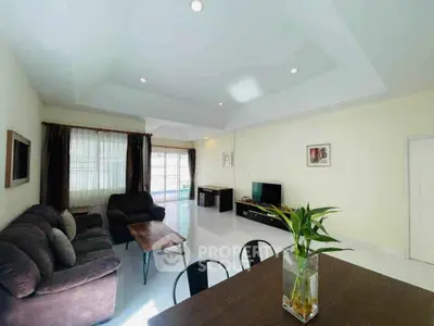 Spacious living room with modern furniture and natural light, perfect for relaxation and entertainment.