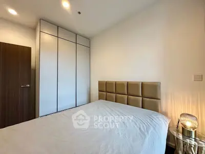 Modern bedroom with stylish headboard and built-in wardrobe