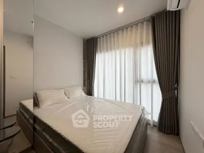 Modern bedroom with large window and elegant curtains in a stylish apartment.