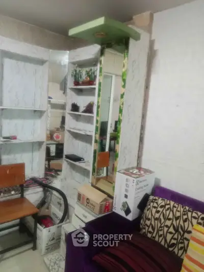Cozy living room with modern decor and vibrant furniture, featuring a mirror and shelving unit.