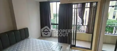 Spacious bedroom with large windows and garden view in modern apartment.