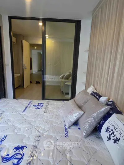 Modern bedroom with sliding glass door and stylish decor in a contemporary apartment.
