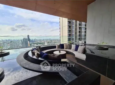 Luxurious high-rise balcony with stunning city skyline view and modern seating area.