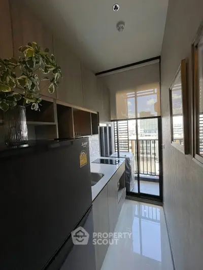 Modern kitchen with sleek appliances and balcony view in a stylish apartment.