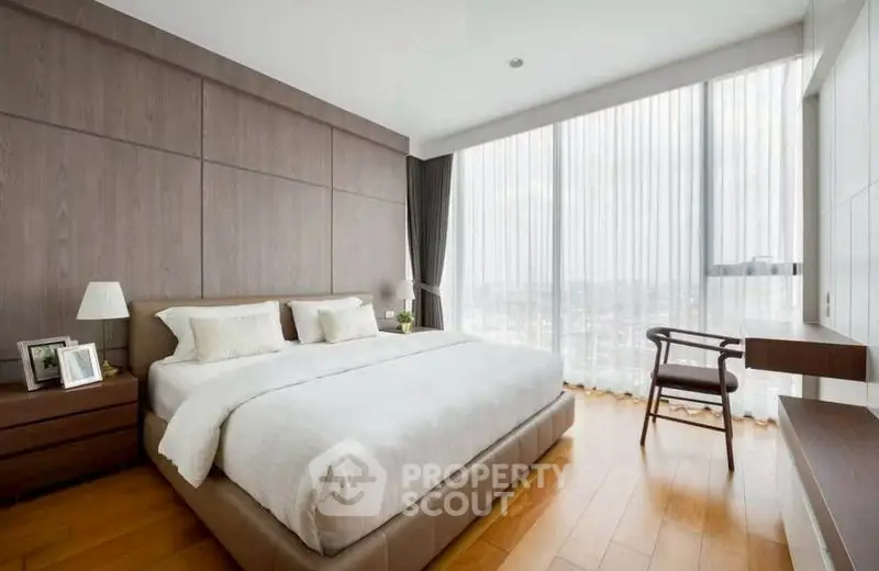Luxurious bedroom with panoramic city view and elegant wooden flooring.