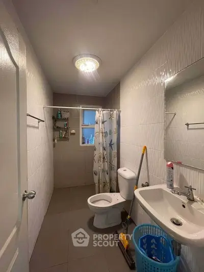 Cozy bathroom with modern fixtures and ample storage space.