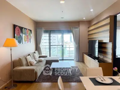 Spacious modern living room with large windows and stylish decor in a high-rise apartment.