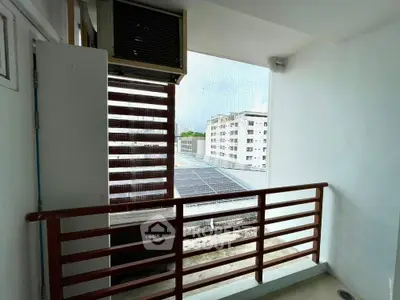 Cozy balcony with city view and air conditioning unit, perfect for relaxation.