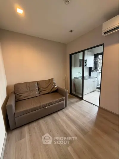 Modern living room with sleek sofa and view into contemporary kitchen
