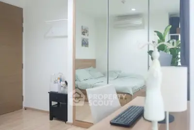 Modern bedroom with mirrored closet and workspace, featuring sleek design and natural light.