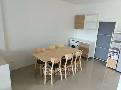 Modern kitchen with wooden dining set and washing machine in open layout