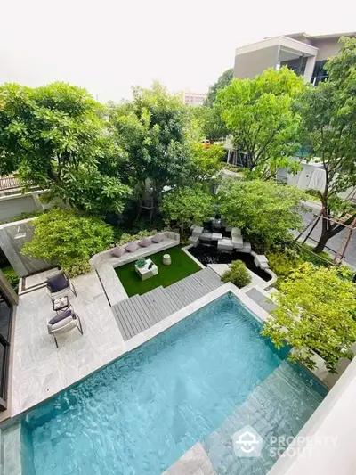 Luxurious modern backyard with pool and lush greenery, perfect for relaxation and entertainment.