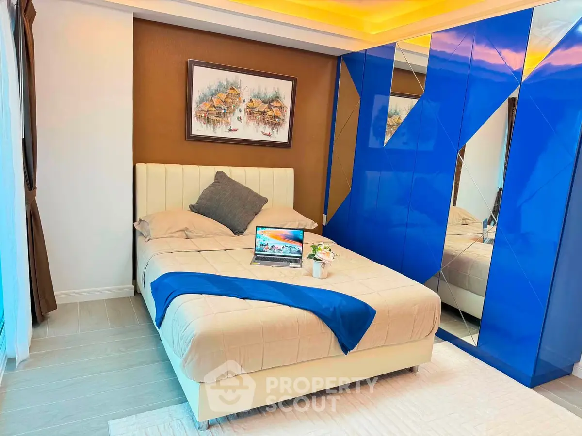 Modern bedroom with stylish blue mirrored wardrobe and cozy bed setup