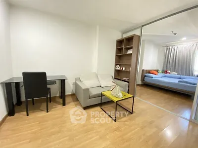 Modern studio apartment with cozy living area and bedroom, featuring wooden flooring and ample natural light.