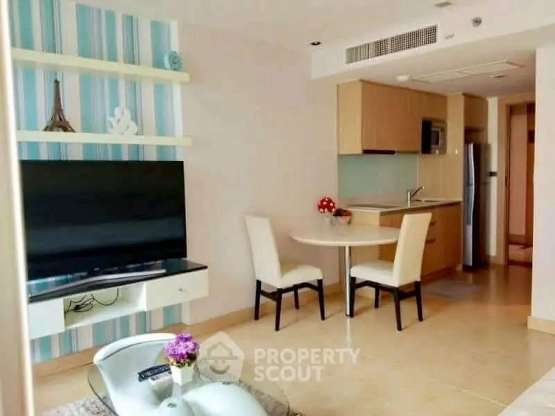 Modern living room with open kitchen, featuring sleek furniture and stylish decor.