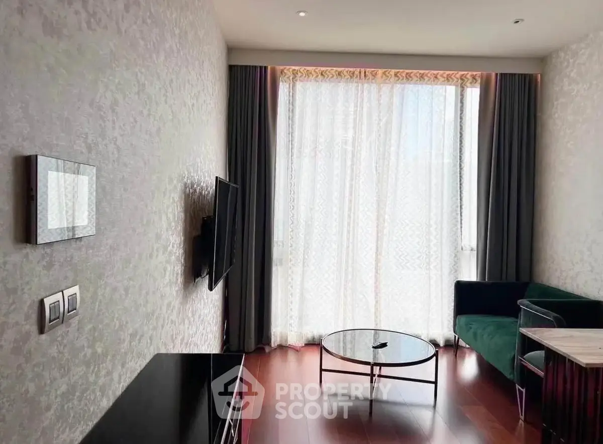 Modern living room with elegant decor and large window, featuring stylish furniture and hardwood flooring.