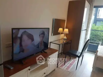 Modern living room with TV, desk, and balcony view in stylish apartment.