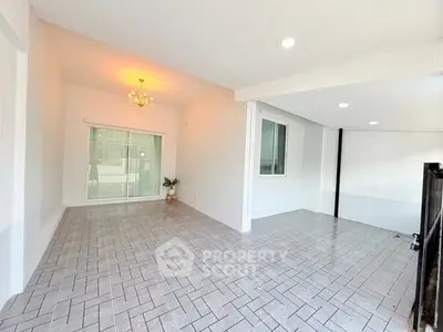 Spacious open-plan living area with elegant lighting and large windows.