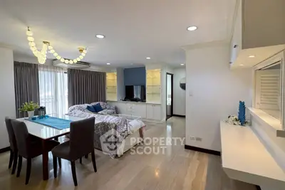 Spacious living room with elegant decor and natural light, featuring a cozy seating area and modern dining space.