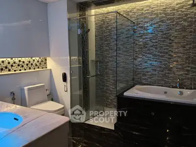 Luxurious modern bathroom with glass shower and elegant bathtub
