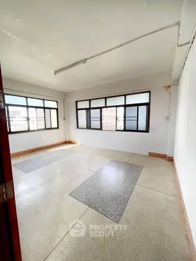 Spacious unfurnished room with large windows and natural light, ideal for customization.