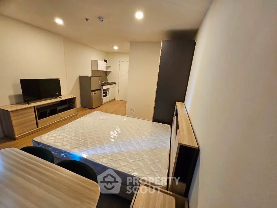 Modern studio apartment with open layout, featuring a kitchenette and cozy living area.
