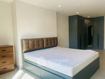 Spacious modern bedroom with stylish furniture and ample natural light.
