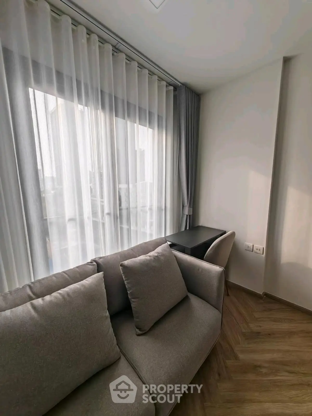 Cozy living room with modern sofa and elegant curtains in a bright apartment.