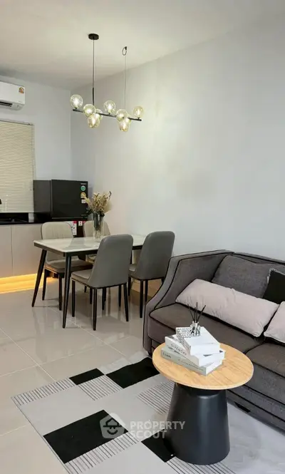 Modern living room with stylish furniture and dining area, featuring elegant lighting and contemporary decor.