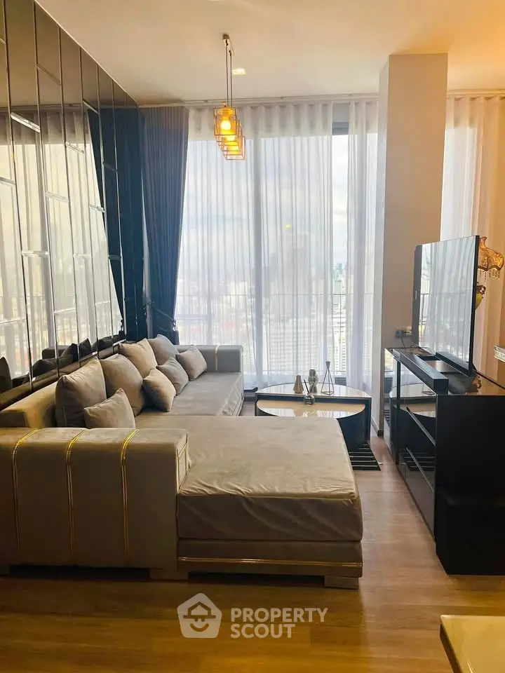 Modern living room with large windows and stylish decor in a high-rise apartment.