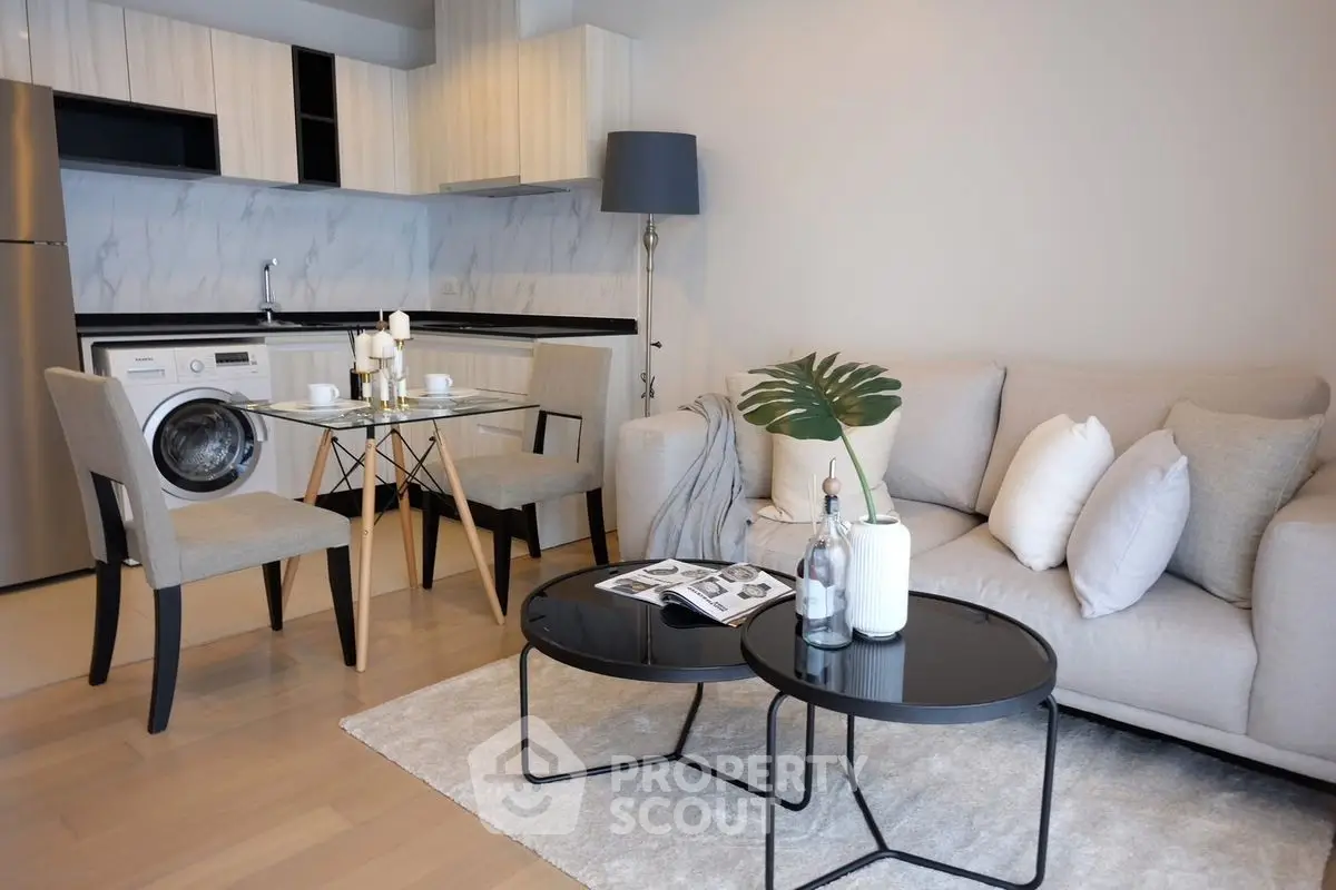 Modern living room with open kitchen, stylish furniture, and cozy ambiance.