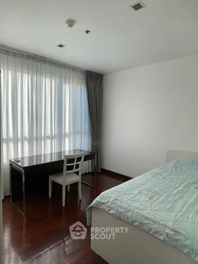 Spacious bedroom with large window and study desk, perfect for natural light lovers.