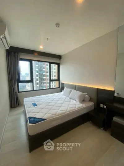 Modern bedroom with large window and city view in high-rise apartment
