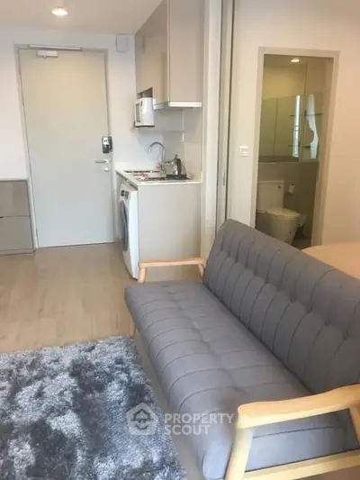 Modern apartment interior with cozy living area and compact kitchen