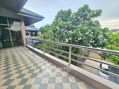 Spacious balcony with tiled flooring and lush garden view in modern home
