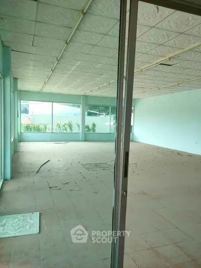 Spacious empty room with large windows and tiled floor, ideal for customization.