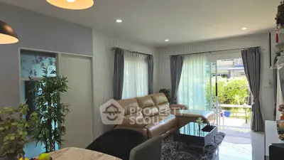 Spacious living room with modern decor and large windows opening to a garden view.