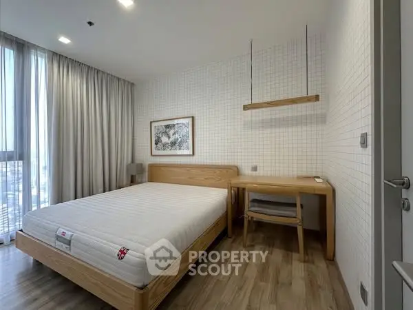 Modern minimalist bedroom with wooden furniture and large window view.