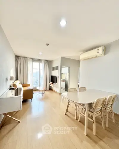 Spacious living room with modern furniture and natural light in a stylish apartment.