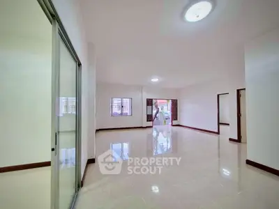 Spacious open-plan living room with large windows and sliding doors