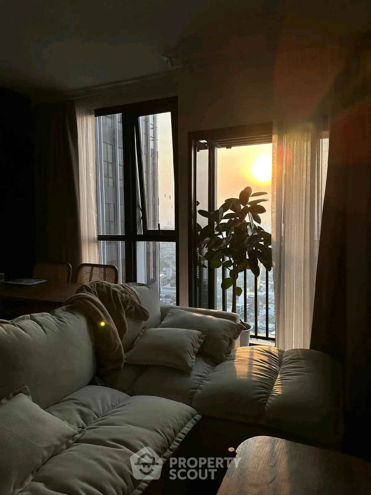 Cozy living room with sunset view and plush sofa, perfect for relaxation.