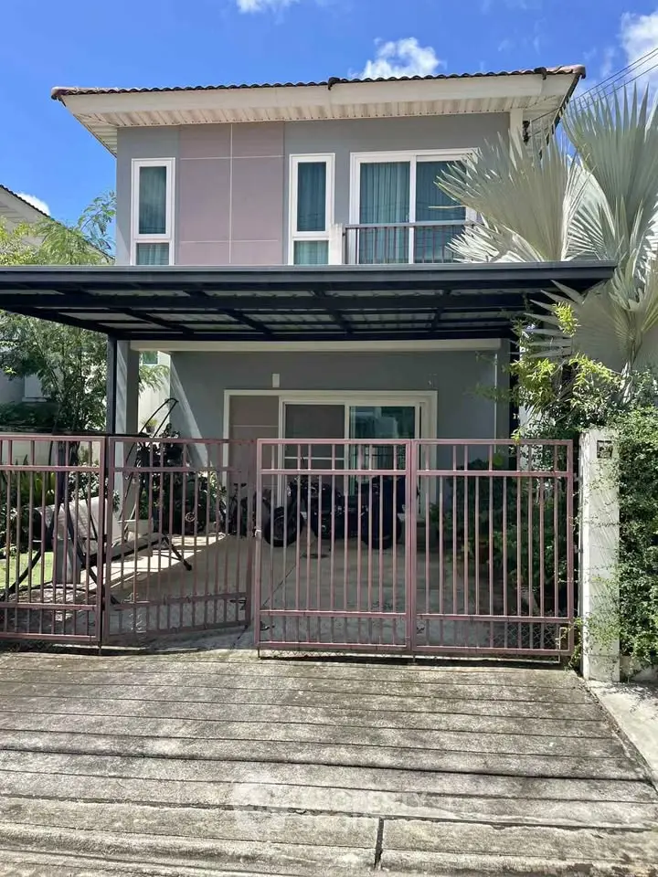 Charming two-story house with gated entrance and lush greenery